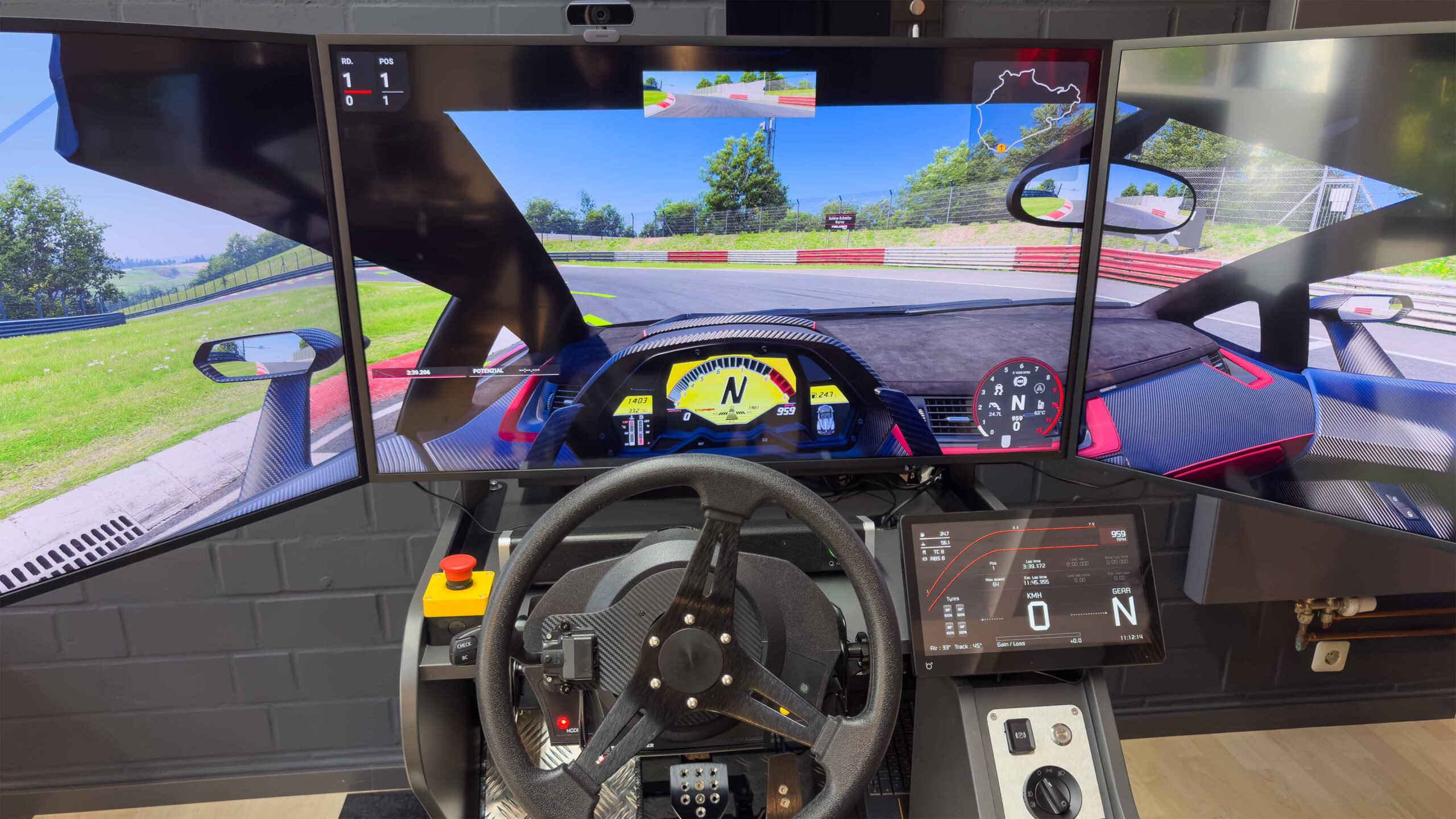 Nahaufnahme eines professionellen Fahrsimulators in Julians Fahrschule Kleve mit drei UHD-Monitoren, Direct-Drive-Lenkrad und Cockpit-Sicht auf eine Rennstrecke.